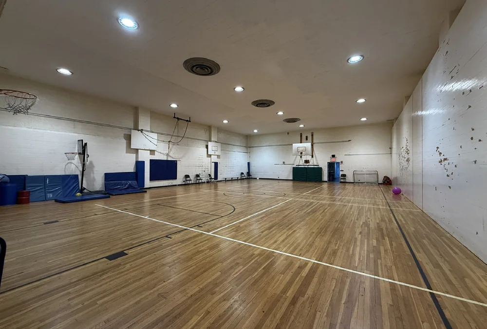 Basketball court and hoops inside the school's indoor gymnasium
